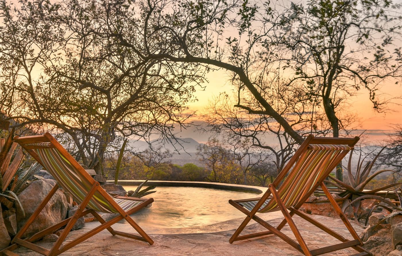 Deck chairs by the infinity pool at sunset