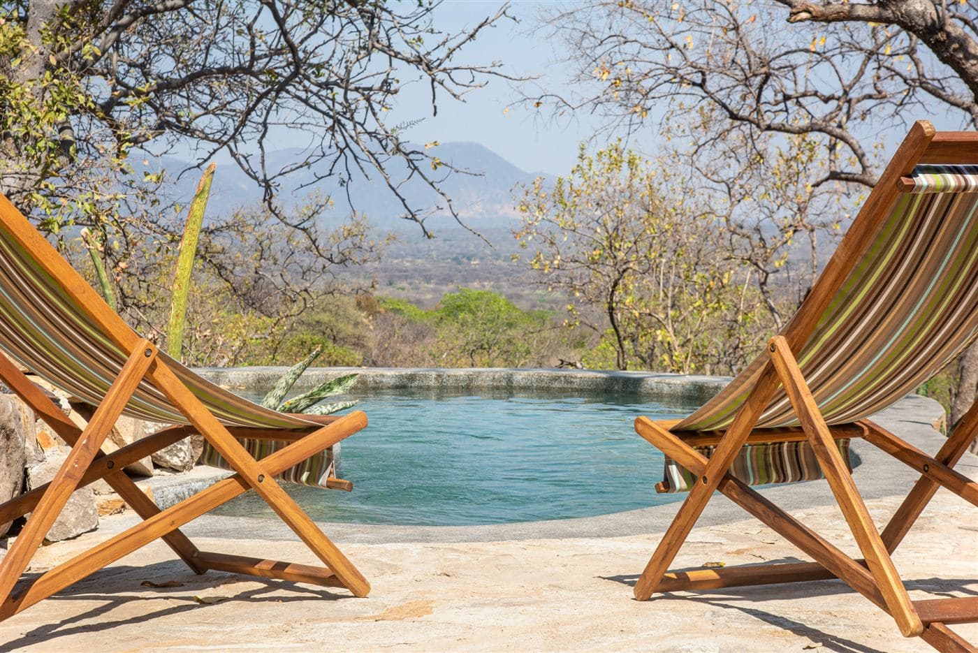 The infinity pool and deck chairs with a mountain view